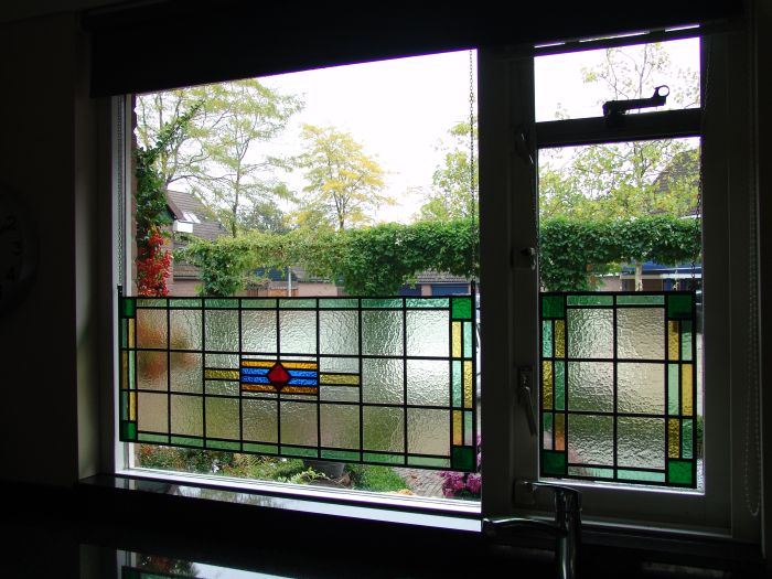 Nieuw glas-in-lood tegen inkijk, in stalen frame opgehangen.