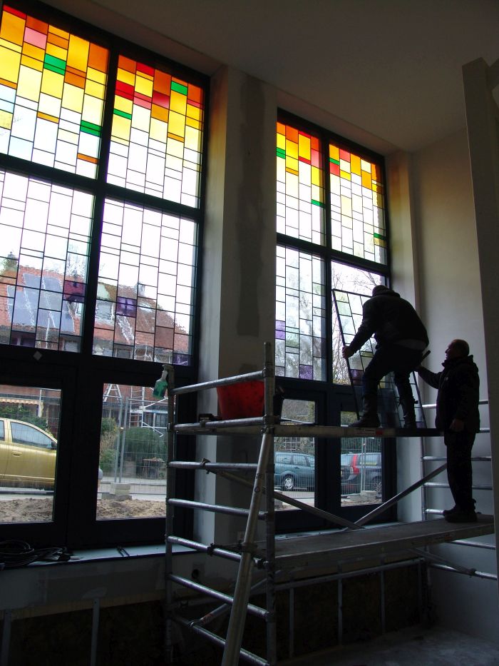 Glas in lood in dubbelglas wordt door de glaszetters geplaatst