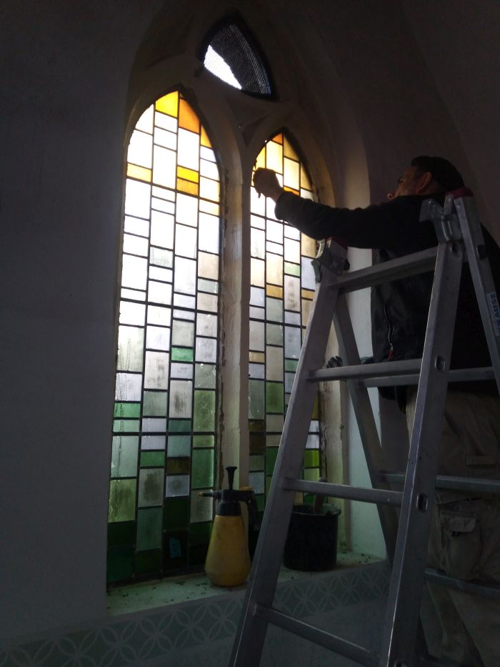 Glas in lood wordt geplaatst door steenhouwer