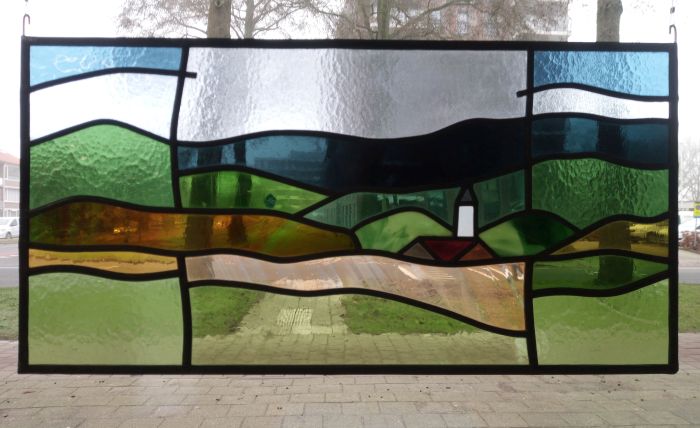 Glas in lood met heuvellandschap en dorpskerk